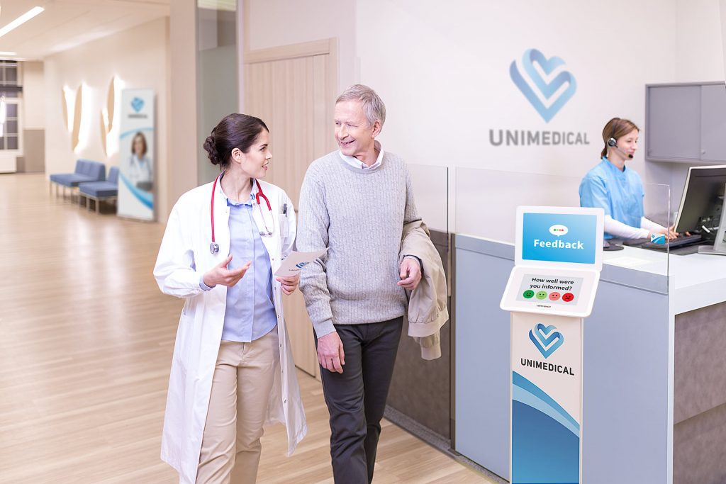 Patients providing feedback on a HappyOrNot Kiosk